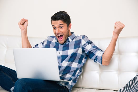 Portrait of excited man looking game on laptop at home-1